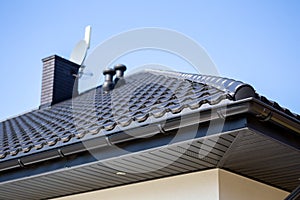 Corner of the new modern house with roof, gutter, ventilation chimneys and satellite dish