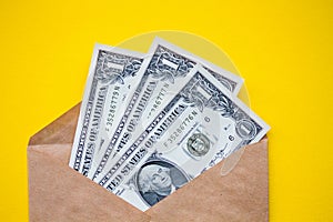 In the corner of the photo is a white envelope with a hundred-dollar bill on a yellow background. Symbol of profit