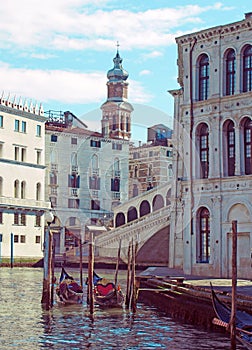 a corner the rialto area of central venice on a sunlit morning with gondolas moored next to the grand canal and old buildings