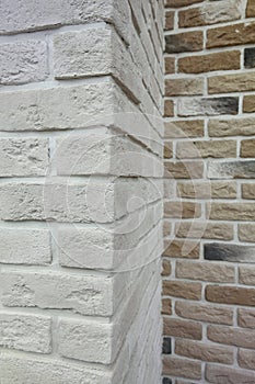 The corner structure of the house. Texture - artificial decorative stone faÃÂ§ade. grey color rough stone wall background texture.