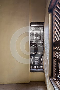 Corner of two Interleaved wooden ornate windows - Mashrabiya - in stone wall photo