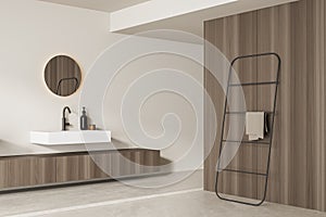 Corner view on bright bathroom interior with sink, round mirror