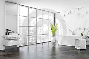 Corner view on bright bathroom interior with white bathtub, sink