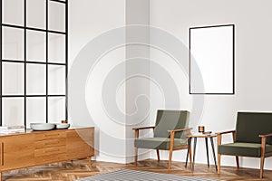 Corner view of living room with canvas on white wall and armchairs