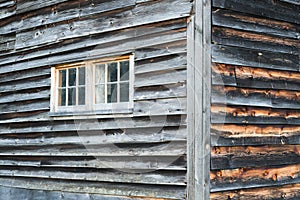 Corner of Weathered Barn Wall with Windows and Rustic Wood Siding.