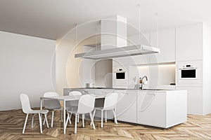 Corner of white kitchen with a table