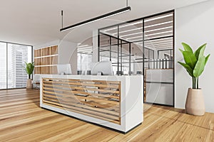 Corner of white office reception with wood panels and open space