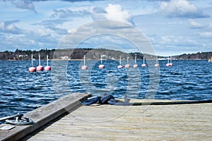 Corner of the wooden empty pier with mooring rope on the sea bay.