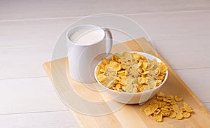 Cornflake cereals in a bowl with milk on light background, quick breakfast