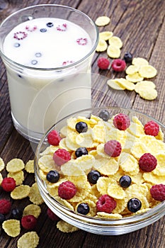 Cornflakes with berries and cup of milk