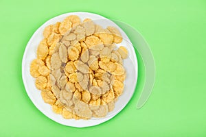 Cornflakes isolated close up on green