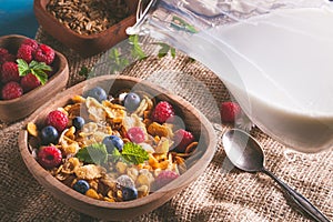 Cornflakes and other cereals with fresh fruits of raspberries, blueberries and milk on healthy breakfast