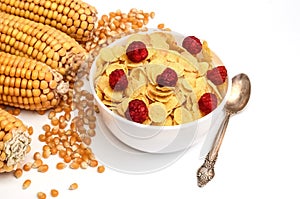 Cornflakes with raspberries and ears of corn close-up isolated on a white background. Healthy food, breakfast