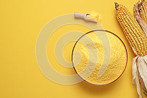 Cornflour in a bowl top view. Bowl with polenta isolated on yellow background
