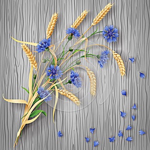 Cornflowers and wheat ears bunch on wood background