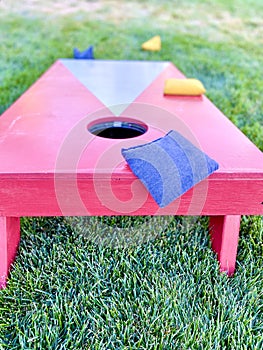 Cornhole board with bean bags on lawn