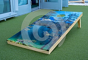Cornhole platform with nature theme sitting on turf photo