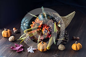 Cornucopia centrepiece filled with autumn decorations against a black background. photo