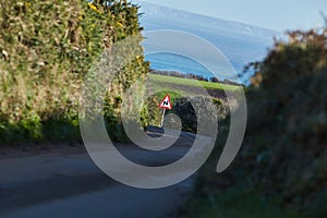 Cornwall, UK - Traffic sign warning of curvy road ahead in typical Cornwall landscape