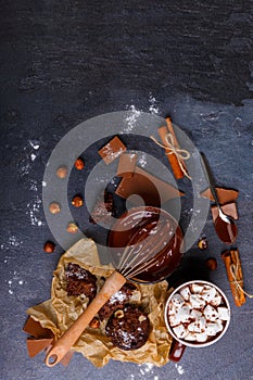 Corolla in a cup of melted chocolate and sweets side by side. View from above photo