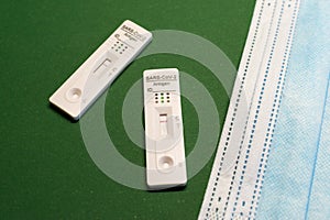 Corona antigen rapid test and masks on green background