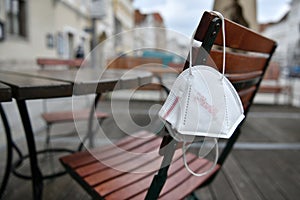 Corona crisis - lockdown - FFP2 mask hangs on a chair in an empty beer garden in Steyr, Austria, Europe photo