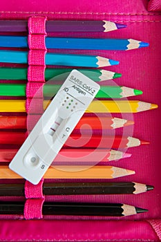 Corona Sars-CoV-2 antigen test with a positive result on a colored pencil in a pencil case.