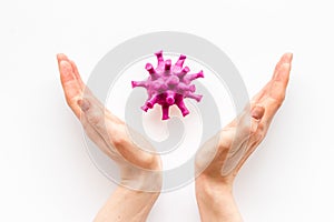 Corona virus Covid-19 - diagnostics concept with strain virus model and hands - on white background top-down