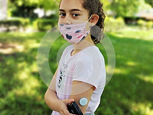 Corona virus  and diabetes. Girl with the mask on face checks glucose level