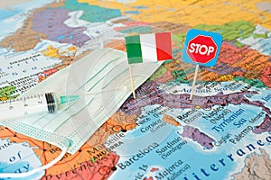 Corona virus pandemic in Italy concept image lockdown flag, stop sign, syringe, medical mask on map, restrictions border shutdown