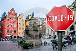 Corona virus stop sign with view of historic old town in Stockholm, Sweden. Warning about epidemic quarantine. Coronavirus disease