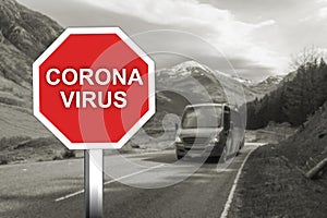 Corona virus warning sign on the road with turists and imigrants on bus photo