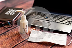 Corona virus, work from home kit on wooden office desk with hand sanitizer and face mask, a solution against the outbreak of covid photo