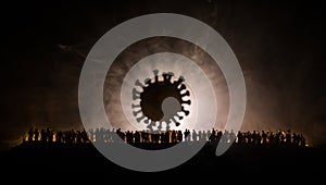 Coronavirus 2019-nCov novel coronavirus concept. Crowd looking on big Corona virus model at night with fog and backlight. Creative