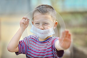 A Coronavirus and air pollution PM2.5 concept. European little boy wearing mask for protect pm2.5 and shows stop hand gesture to