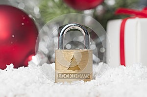 Coronavirus Christmas lockdown: a lock on the snow surrounded by red and green christmas decorations