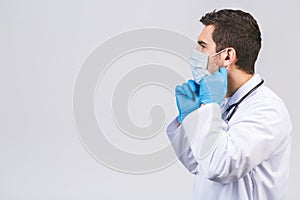 Coronavirus concept. Man Doctor Puts on Medical Mask Isolated over white background. Covid-19 flu pandemic