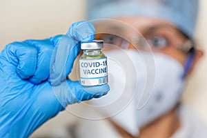 Coronavirus conceptual image of Indian nurse holding a vaccine bottle used for treating Covid-19 patients