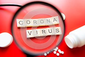 Coronavirus COVID-19 concept image wit text seen through a magnifying glass. Red Background