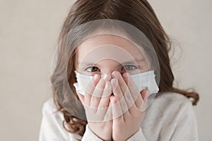 Coronavirus COVID-19 epidemic outbreak quarantine concept of small ill kid in medical mask wants to sneeze