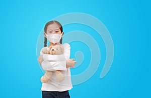 Coronavirus covid-19 and pollution protection concept. Asian little kid girl hugging teddy bear doll with wearing mask to against