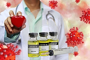 Coronavirus Covid-19 Vaccine in bottle and syringe for against virus and concept model with doctor holding red heart in hand