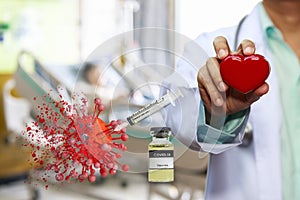 Coronavirus Covid-19 Vaccine in bottle and syringe during injection to destruction virus model with doctor holding red heart on