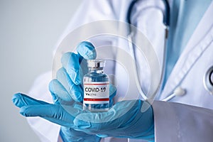 Coronavirus COVID-19 vaccine and immunization concept. doctor hand holding vaccine bottle for injection use. corona virus prevent