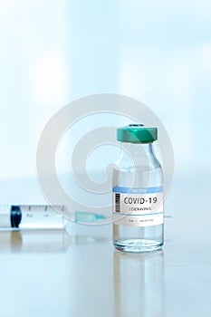 Coronavirus COVID-19 Vaccine Vials and Syringe On Reflective Surface