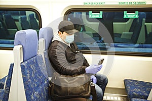 Coronavirus, covid 2019, Man with respiratory mask traveling in the public transport by train