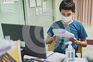 Coronavirus or covid-19. Asian men wearing mask protection, work from home with disinfectant gel