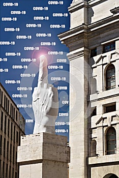 Coronavirus Covid-19 in Milan.. Sculpture of Cattelan`s finger in front of the Milan Stock Excha photo