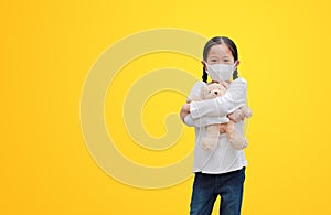 Coronavirus covid-19 and pollution protection concept. Asian little child girl hugging teddy bear doll with wearing mask to