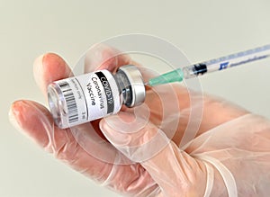 Coronavirus COVID-19 vaccine bottle, vial, container, in hand with gloves at Pfizer photo